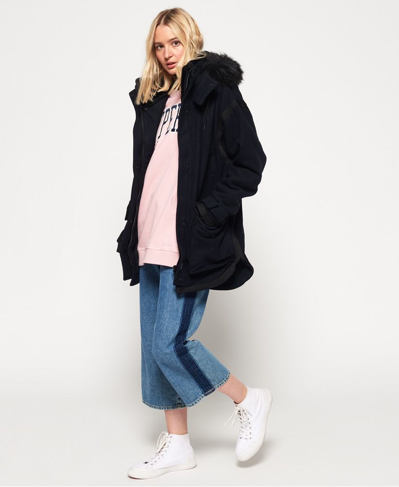 Superdry women’s Fjord Ovoid parka coat. With a wool blend fabric this premium coat is perfect for keeping warm whilst looking stylish this season and features a detachable drawstring hood with a zip and a faux fur trim which is also detachable, a super soft fleece lined collar and a single zip and popper fastening. The Fjord Ovoid parka coat features six external front pockets, four of which have popper fastenings. This coat is finished off with detailing on the seams, a metal Superdry logo badge on one of the pocket openings and a Superdry logo patch near the hem.