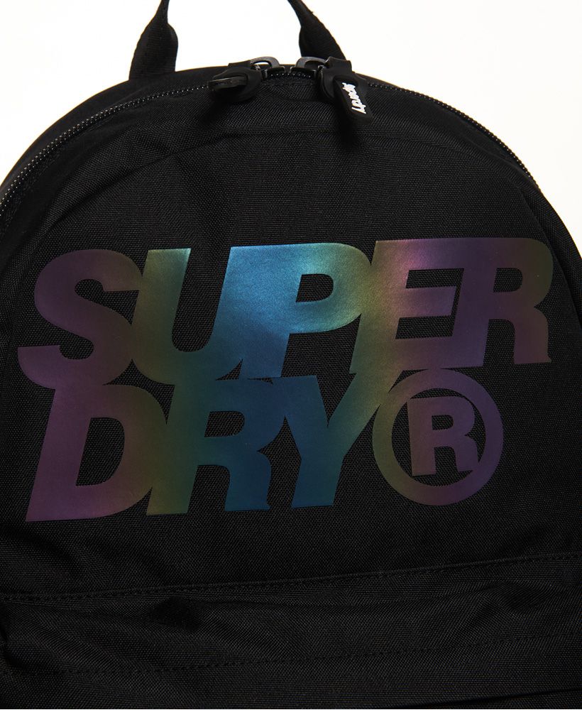 Superdry men's Holographic Lineman Montana rucksack. This classically styled rucksack features a large zip fastened main compartment, a top grab handle and padded back and straps. This rucksack also features an outer zip fastened compartment and two side pockets with popper fastenings. The rucksack is finished with a holographic effect Superdry logo on the front and a silicone logo badge on one strap. 21 litre approximate main compartment capacity.H 46cm x W 30.5cm x D 13.5cm