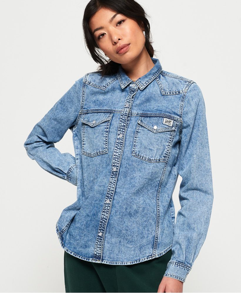 Superdry women's Western denim shirt. This long sleeved shirt features two front pockets on the chest and popper fastenings. Finished with a metal Superdry badge on one of the pockets. The Western denim shirt is effortless, why not try tying at the front for an on trend look.