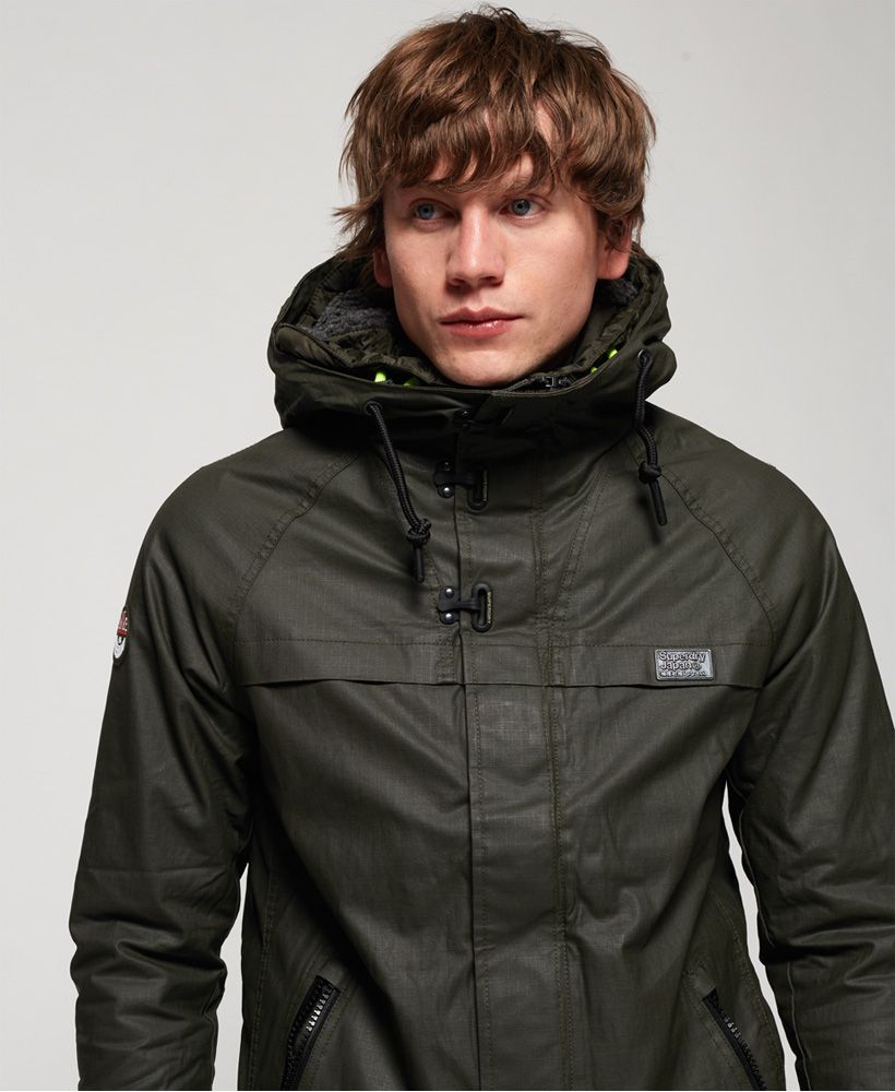 Superdry men’s Double Atlantic jacket. Taking inspiration from maritime styling, the Double Atlantic jacket is made from a coated cotton fabric and features a double layer zip fastening with a hook and loop storm flap and clips for added stability, a double layer hood, two front zipped pockets and popper cuffs. Inside, the jacket has a fully fleece lined body with fleece lining in both hoods. The jacket also has a single inside pocket. The Double Atlantic jacket is finished with a rubber Superdry logo badge on the sleeve, an acrylic Superdry logo on the shoulder and a metal Superdry logo on the chest.