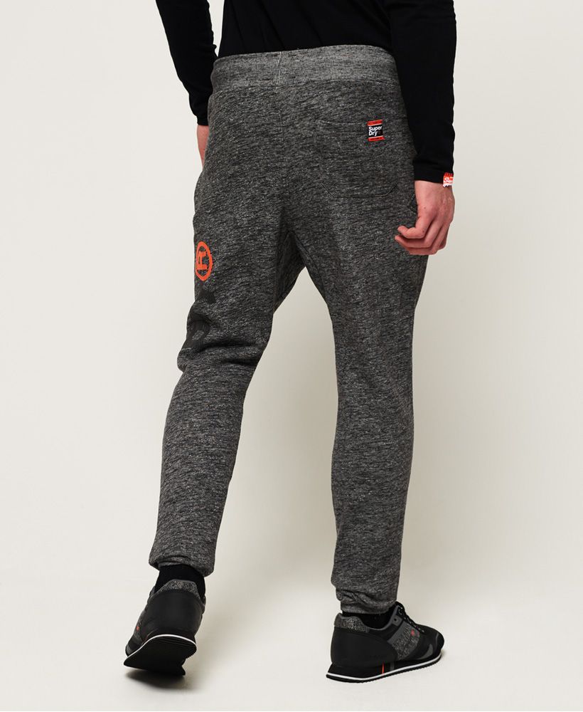 Superdry men's Time Trial angled pocket joggers. These joggers feature an elasticated drawstring waistband, ribbed cuffs, two zip fastened front pockets and one back pouch pocket. Finished with a textured Superdry logo down one leg and a Superdry logo badge on the back pocket.