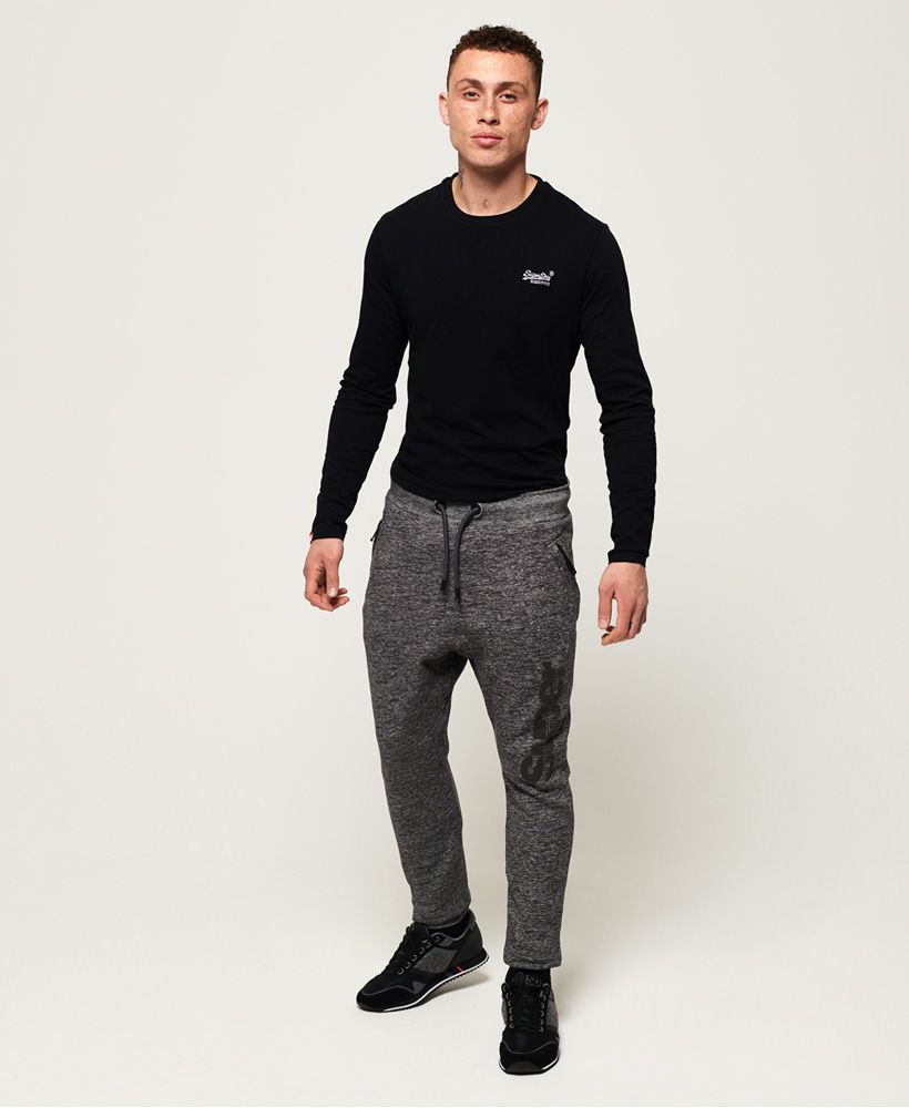 Superdry men's Time Trial angled pocket joggers. These joggers feature an elasticated drawstring waistband, ribbed cuffs, two zip fastened front pockets and one back pouch pocket. Finished with a textured Superdry logo down one leg and a Superdry logo badge on the back pocket.