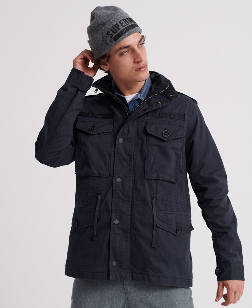 Superdry men's Rookie Field jacket. This jacket features a main zip and popper fastening, a four pocket design, a drawstring waist tie and popper adjuster cuffs. This jacket also features a small inside pocket, perfect for a wallet or phone, shoulder epaulettes and zip detailing on the collar. Finished with Superdry logo badges on the chest and on one sleeve.