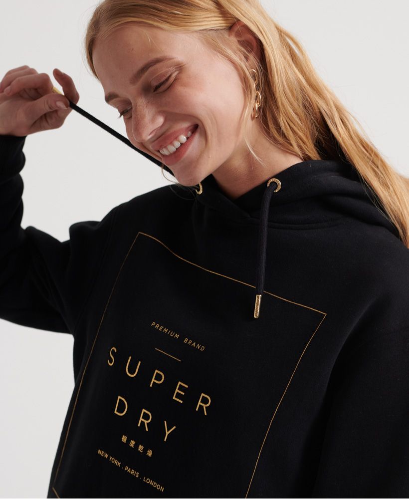 Superdry women's Oversized Scandi hooded dress. This hooded dress features a Superdry graphic across the chest, two pockets, and ribbed hem and cuffs. Completed with an adjustable drawstring hood and printed Superdry Logo on the hem.