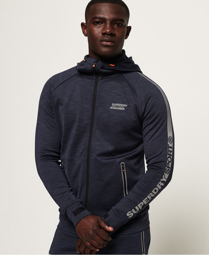 Superdry men's Active lite training zip hoodie. Designed with quick dry, breathable fabric and moisture wicking technology to help keep you cool and dry when working out. This hoodie features a main zip fastening, bungee cord hood, two zip fastened pockets and thumbholes in the cuffs. Completed with reflective detailing on the pockets and a reflective Superdry logo on the chest and down one sleeve.