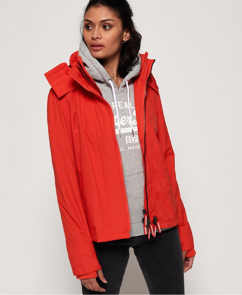 Superdry women’s Tech hooded Pop Zip SD-Windcheater. One of our iconic wind items, this is the essential outdoor jacket featuring a mesh lined body and a bungee cord adjustable hood. This jacket also features a triple layer zip complete with coloured middle teeth, a ribbed inner collar, ribbed cuffs with thumb holes and two zipped front pockets as well as one internal pocket with a popper fastening. The Tech hooded Windcheater has been finished with an embroidered Superdry logo on the back, a rubber Superdry logo on the shoulder and a rubber Superdry badge on the sleeve.
