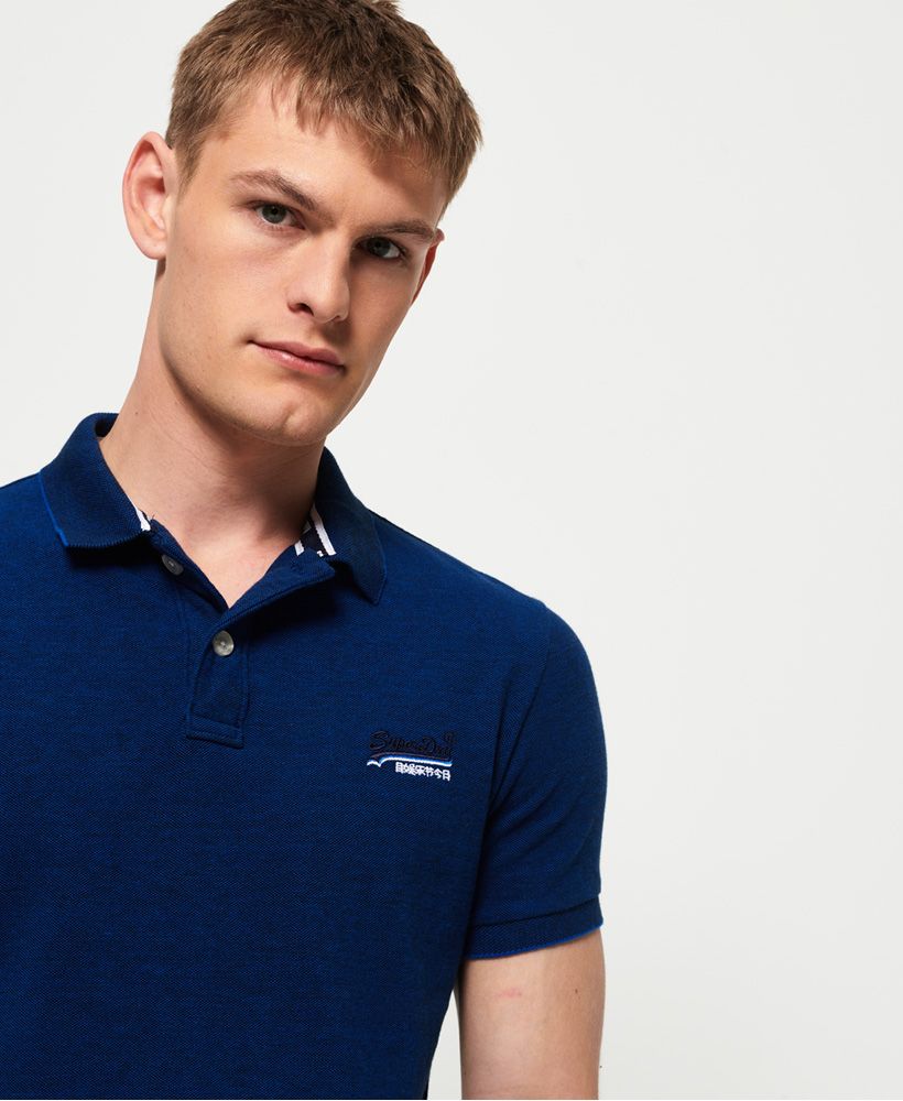 Superdry men's Classic pique polo shirt. This short sleeve polo shirt features a twin button fastening, split side seams and an embroidered version of our iconic logo on the chest. The polo is completed with an applique number graphic and logo tab on the right sleeve.Slim fitMade with Organic Cotton - Made using cotton grown using organic farming methods which minimise water usage and eliminate pesticides, maximising soil health and farmer livelihoods.