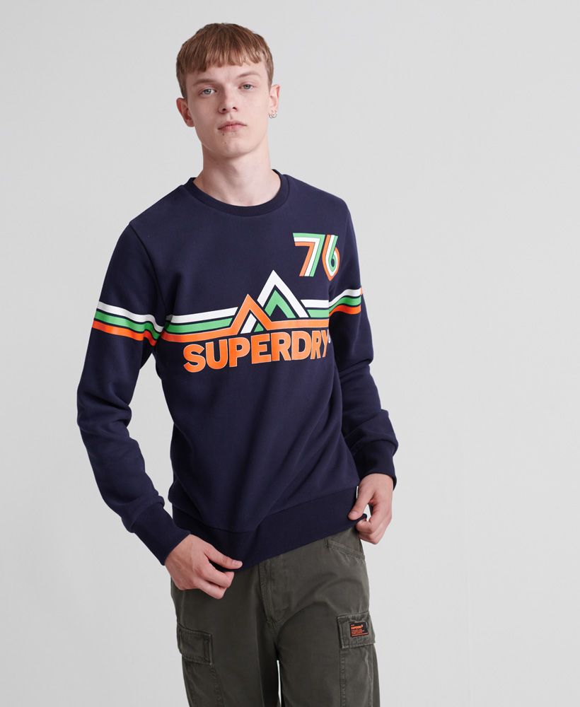 Superdry men's Downhill Racer crew jumper. This classic crew neck jumper features a textured Superdry print across the chest, and ribbed hem and cuffs. The jumper is finished with a Superdry logo tab above the hem. This jumper is the perfect addition to your wardrobe this season.Slim fit