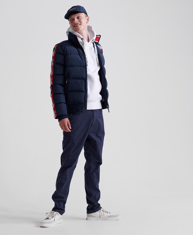 Superdry men's Icon Sports puffer jacket. This puffer jacket features a main zip fastening with zip pockets, ribbed cuffs and hem and a pattered fleece inside. Finished with an embroidered Superdry logo on the chest and reverse with Superdry tape detailing down the arms. The Icon Sports puffer is a great addition to your outwear wardrobe this season.