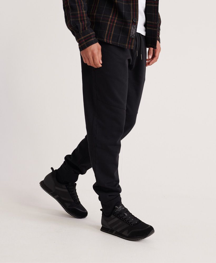 Superdry men's Rookie Utility Joggers. These comfy joggers feature a drawstring waist and three zip fastened pockets. Finished with a Superdry logo tab above the back pocket. Pair with your favourite trainers for a casual look.Relaxed fit