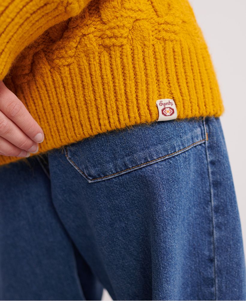 Superdry Sophie Ann Cable knit jumper. This jumper is perfect for those winter months where you want to bring the cosyness of your sofa to work. Paired with any bottoms this makes a perfect outfit. Cable knit pattern throughout and a Superdry logo tag at the hemline.