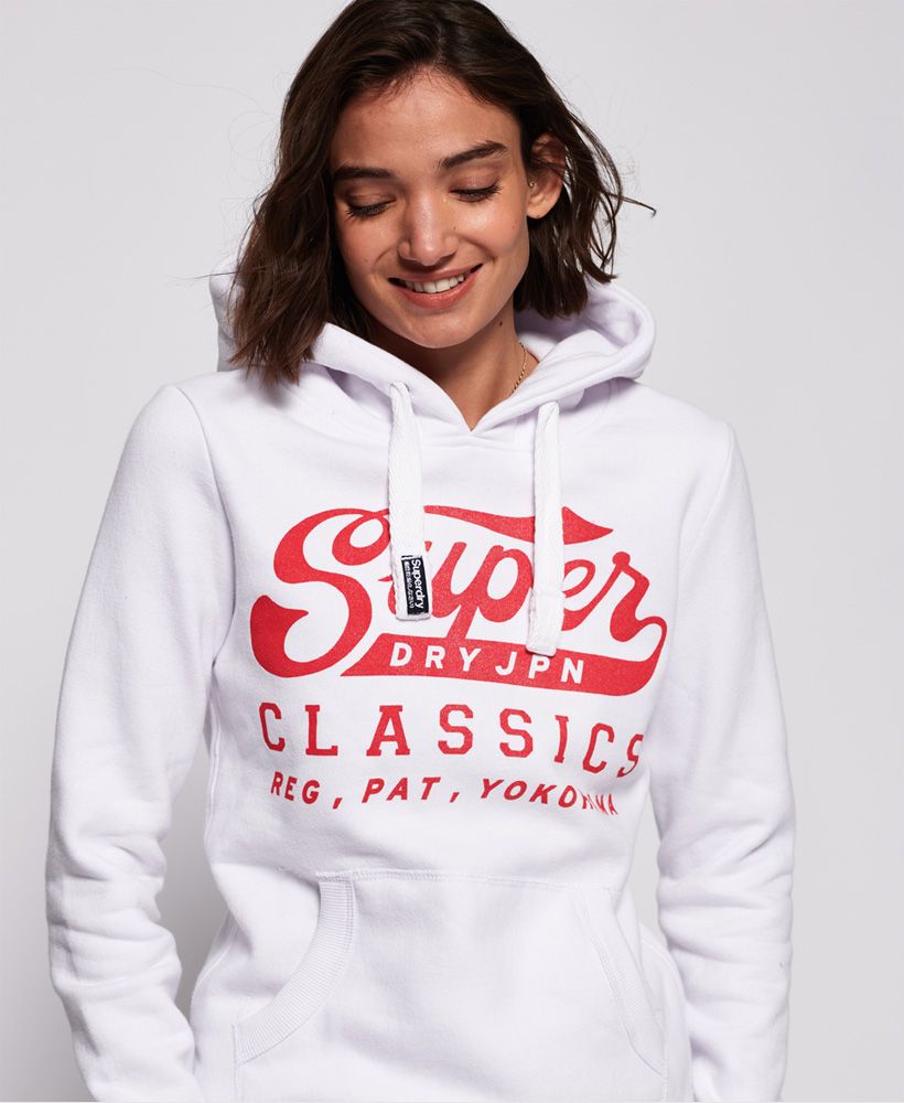 Superdry women's Classics hooodie. This hoodie features a draw cord hood with Superdry logo on the cord, ribbed cuffs and hem. Finished with a Superdry graphic across the body and a discrete Superdry tab on the cuff. The super soft lining of this Classic hoodie means you'll want to wear it all day, every day.