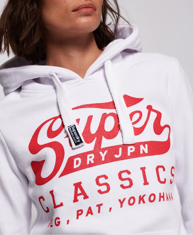 Superdry women's Classics hooodie. This hoodie features a draw cord hood with Superdry logo on the cord, ribbed cuffs and hem. Finished with a Superdry graphic across the body and a discrete Superdry tab on the cuff. The super soft lining of this Classic hoodie means you'll want to wear it all day, every day.