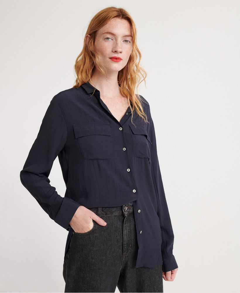 Superdry women's Winter shirt. This long sleeved shirt features a button fastening, twin chest pockets and button fastened cuffs. Finished with a subtle Superdry Edit logo badge to one of the chest pockets and on the back.