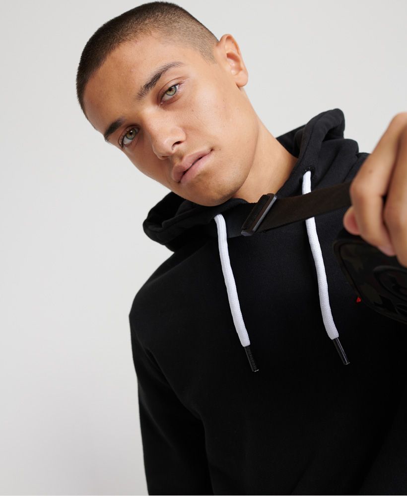 Superdry men's Modern Hit hoodie from the Orange Label range. This hoodie features a drawstring hood, ribbed cuffs and hem and a front pouch pocket. Complete with embroidered stripe detailing on the chest and an embroidered Superdry logo on the hood.