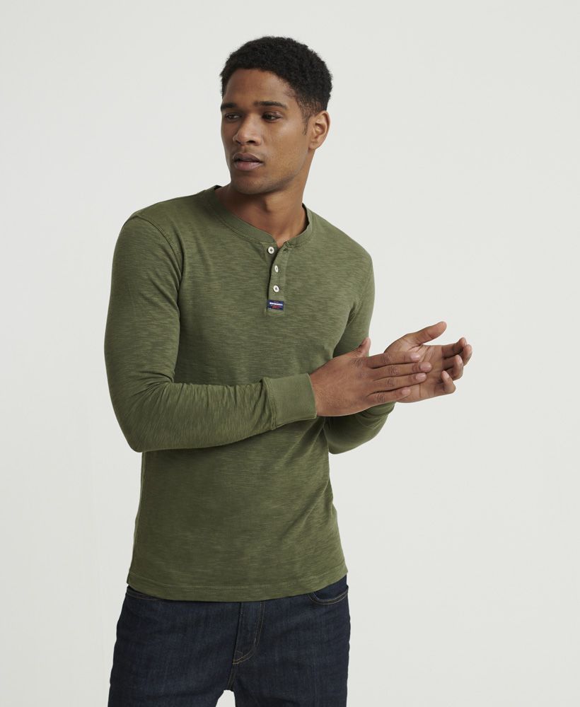 Superdry men's Legacy long sleeve Henley top. A long sleeved top featuring Henley collar with button fastening, and ribbed cuffs. Finished with a Superdry logo patch on the placket, this top is ideal for pairing with jeans or chinos for a smart casual look.