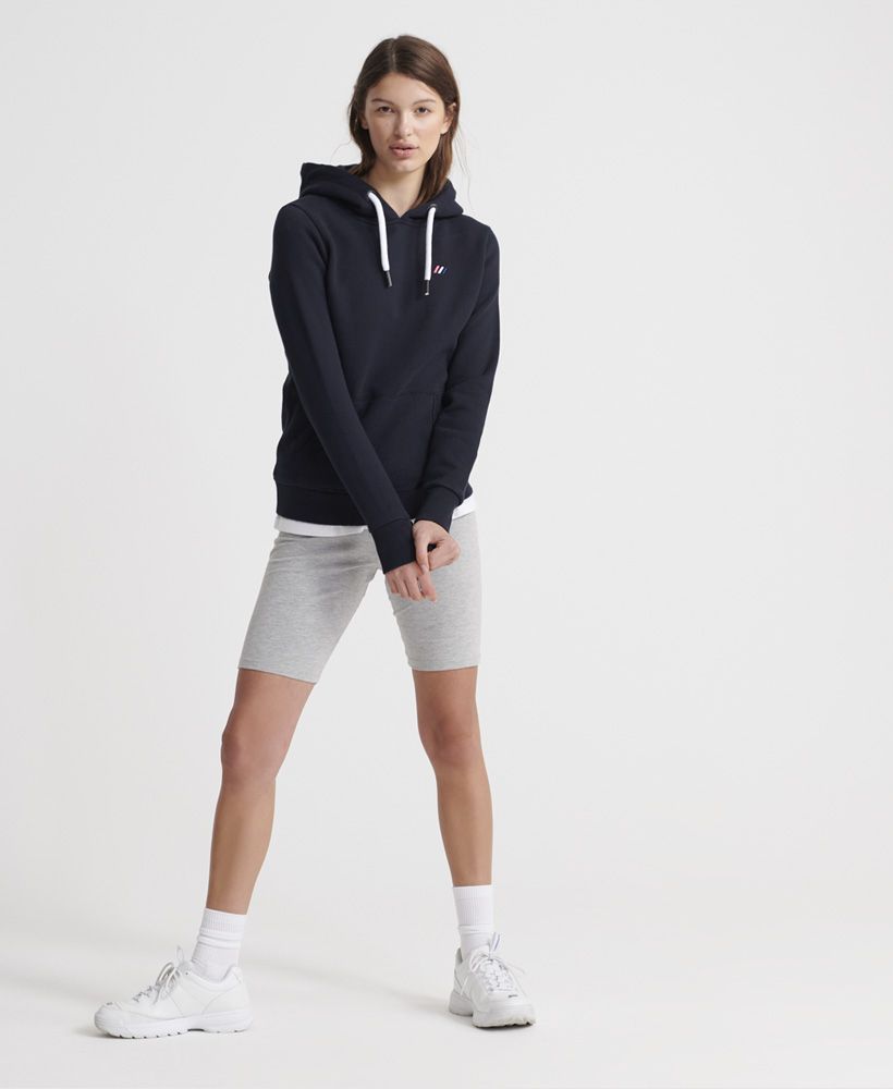Superdry women's Modern Coral Label hit hoodie. This classic overhead hoodie features a drawstring hood, ribbed cuffs and hem, and a front pocket. This is finished with a Superdry logo stitched onto the hood and a small embroidered tab on the chest.Slim fit