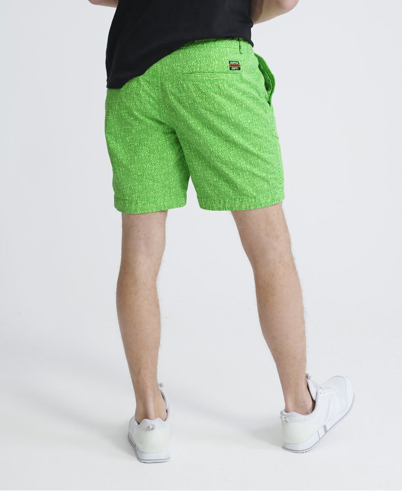 Superdry men's Nue Wave wash shorts. The perfect partner to a crew neck t-shirt, these shorts feature a zip and button fly, four pocket design and belt loops. Finished with a Superdry patch logo above the back pocket and an all over Superdry print.