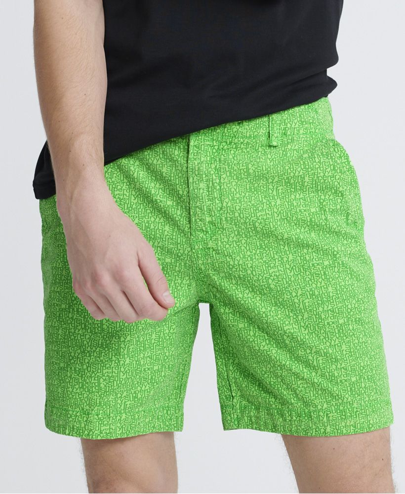 Superdry men's Nue Wave wash shorts. The perfect partner to a crew neck t-shirt, these shorts feature a zip and button fly, four pocket design and belt loops. Finished with a Superdry patch logo above the back pocket and an all over Superdry print.