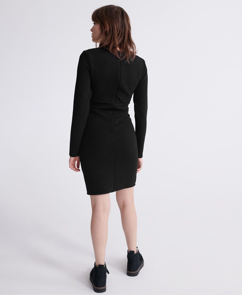 Superdry Daria bodycon dress. This long sleeved bodycon dress features a long sleeved design to complete that perfect silhouette, a back zip fastening and an all over ribbed panel design. Finished with a subtle Superdry metal logo badge.