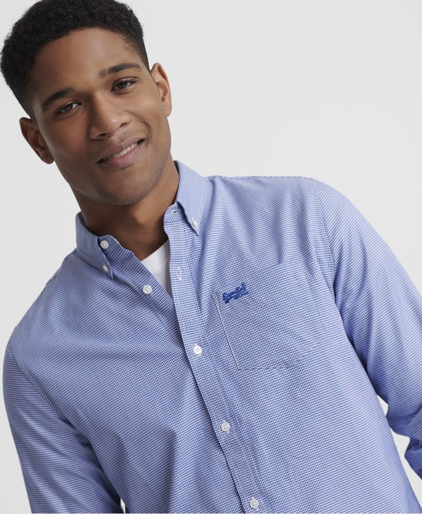 Superdry men's Classic London long sleeve shirt. Add a touch of style to your formal wear this season with the Classic London shirt. Featuring a long sleeve design with button fastening, cuffs and single collar. Finished with a pointed style pocket with a classic Superdry logo embroidered near the top and Superdry patch stitched near the hem.