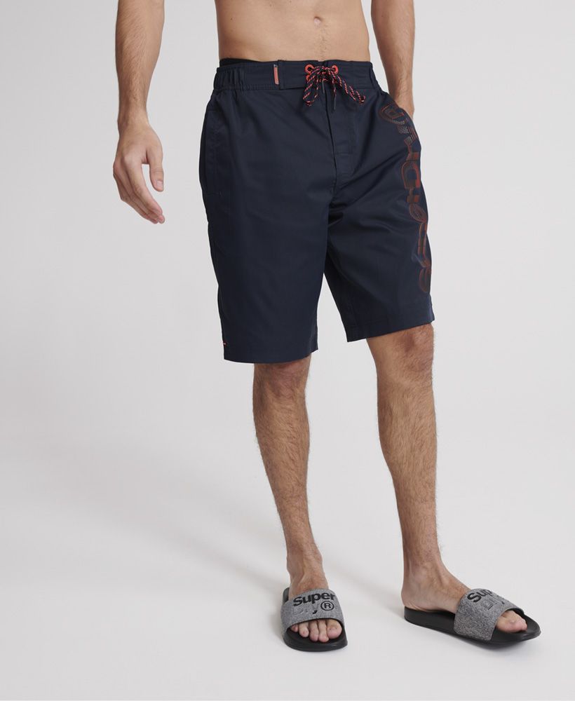 Superdry men's Classic boardshorts. These swim shorts feature a partly elasticated waistband, a single zip fastened pocket on the back, mesh lining and a drawstring and hook and loop fastening, Finished with a textured Superdry print down one leg, a rubber Superdry badge above the pocket, and a rubber Superdry logo tab on the waistband.Please note due to hygiene reasons, we are unable to offer an exchange or refund on underwear, unless they are sealed in their original packaging. This does not affect your statutory rights.