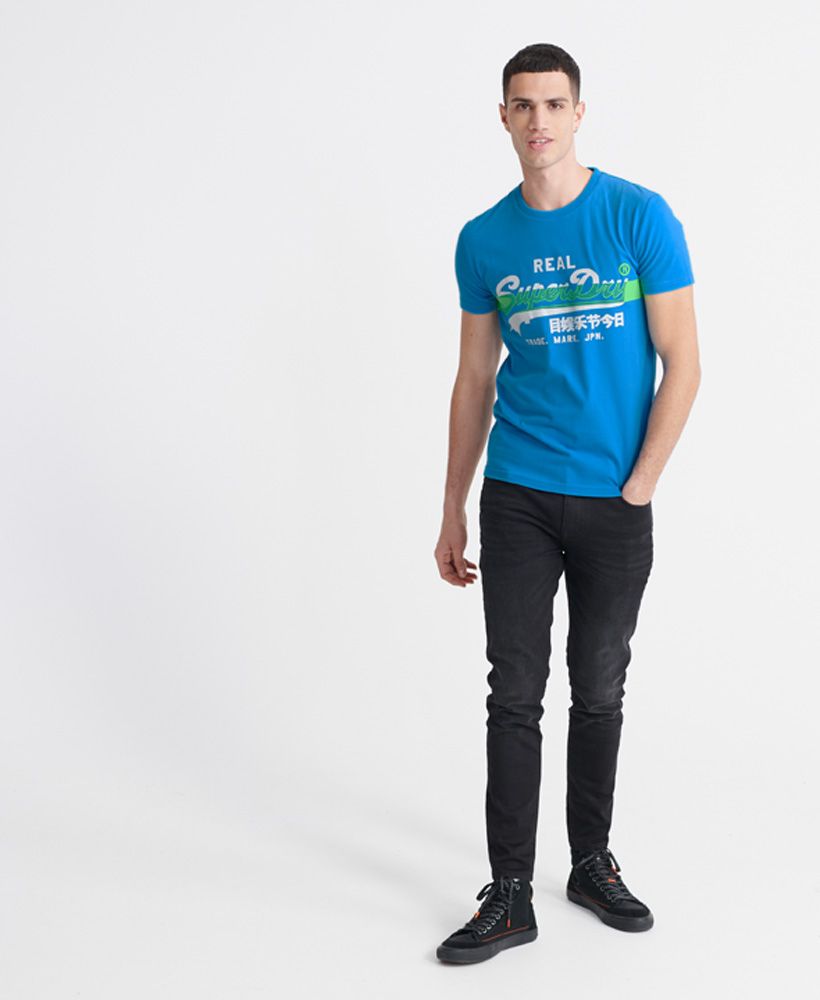 Superdry men's Vintage Logo Cross Hatch T-shirt. A classic style T-shirt featuring a ribbed crew neck, short sleeves and a textured vintage Superdry logo with a cross hatch design across the chest. This tee will be a great new addition to your wardrobe essentials this season.Slim fit