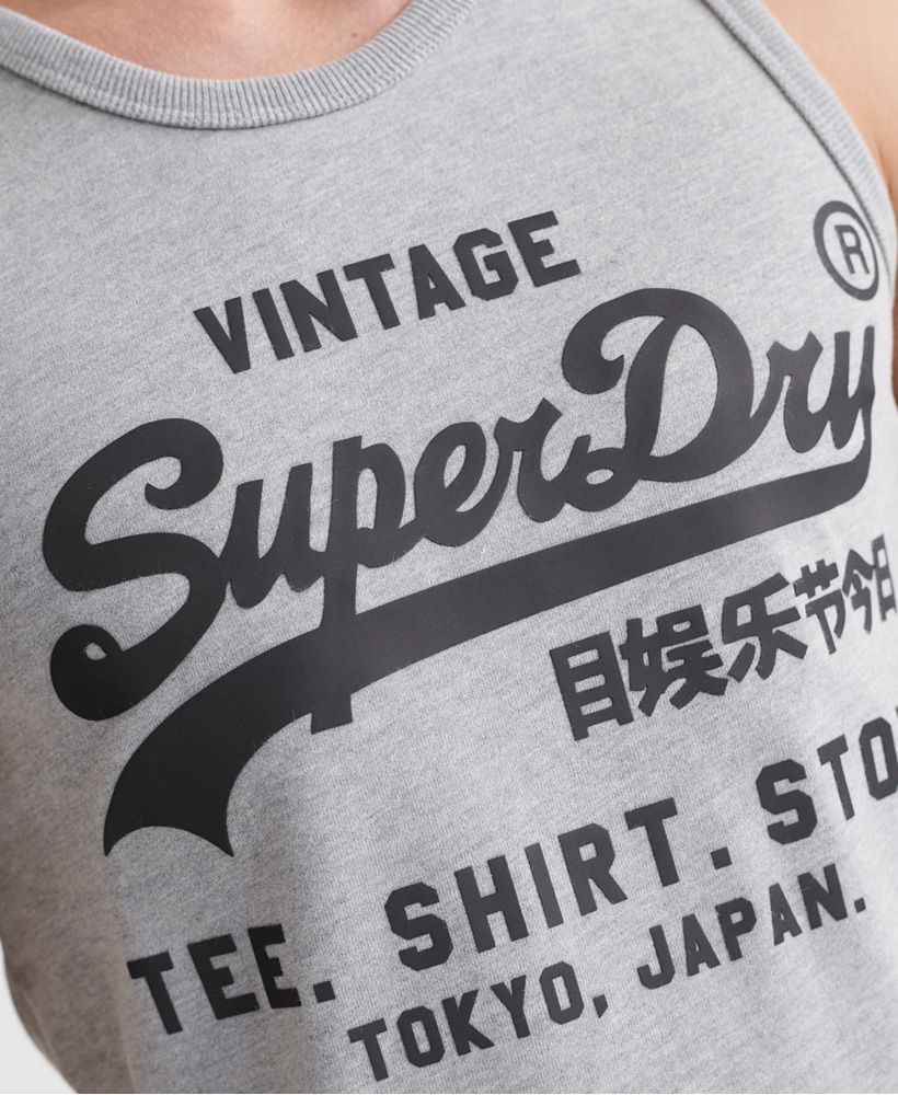Superdry men's Vintage Logo bonded vest top. This sleeveless crew neck top features ribbed trims and is finished with a textured Superdry print across the front.