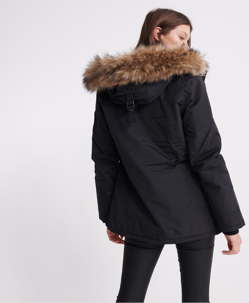 Superdry women's Everest Parka jacket. This jacket features a main two-way zip and button fastening, four front pockets and an attached bungee cord adjustable hood with detachable faux fur fastening. This jacket also features a bungee cord adjustable waist, ribbed cuffs, an inner pocket with a hook and loop fastening and a soft fleece lining in the hood. Finished with a Superdry logo badge on one sleeve.