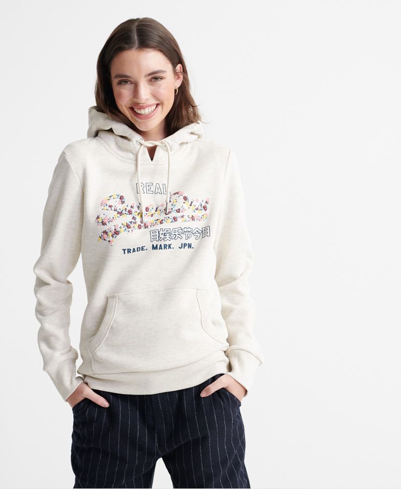 Superdry women's Vintage Logo floral infill hoodie. This overhead hoodie features a drawstring hood, Ribbed hem and cuffs, a front pouch pocket and a soft fleece lining. Finished with a textured Floral Superdry vintage logo on the chest.