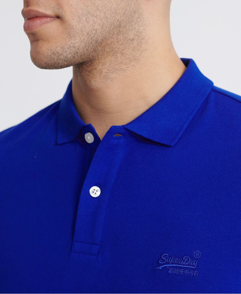 Superdry men's Classic Micro Lite Pique polo shirt made from Organic Cotton. This polo shirt features a button fastening, ribbed collar and cuffs and a reinforced split side seam. Complete with an embroidered Superdry logo on the chest and Superdry logo tab on one side seam. The Classic Micro Lite Pique polo shirt will look great layered with a classic sweatshirt and jeans to complete the look this season.Slim fitMade with Organic Cotton - Made using cotton grown using organic farming methods which minimise water usage and eliminate pesticides, maximising soil health and farmer livelihoods.