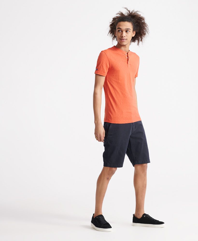 Superdry women's Heritage short sleeved henley T-shirt. This short sleeved tee features a button up design, a henley style collar and ribbed collar and cuffs. Finished with a Superdry logo tab to one side seam.