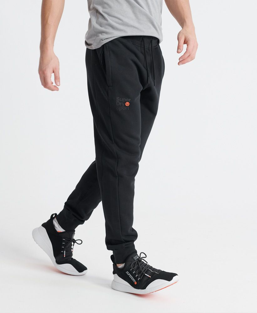 Superdry men's Core sport joggers. These comfortable joggers feature an elasticated drawstring waist, two zip fastened pockets, and ribbed cuffs. Finished with a small Superdry Sport logo print on the front, a Superdry print down the back of one leg, and Japanese characters on the back of the waist.Relaxed: A classic fit. Not too slim, not too tight – no distractions here