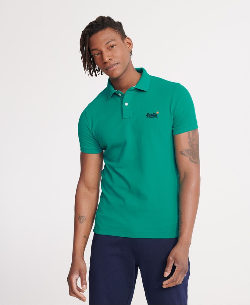 Superdry men's Classic pique short sleeve polo shirt. This classic style polo shirt features a half button fastening, short sleeves and reinforced side splits. Completed with a Superdry logo tab on the side seam and an embroidered Superdry logo on the chest.Made with Organic Cotton - Grown using only organic inputs and no artificial chemicals, which leads to improved soil condition, stronger biodiversity and better health among the cotton growers and uses between 60-90% less water to grow. By 2030, all Superdry Cotton will be Organic.Slim fitMade with Organic Cotton - Made using cotton grown using organic farming methods which minimise water usage and eliminate pesticides, maximising soil health and farmer livelihoods.