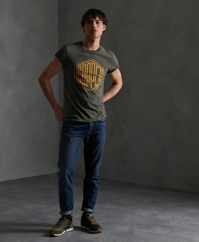 Superdry men's Copper Label T-shirt. Our classic Copper Label t-shirts return this season with this short sleeved tee featuring a crew neckline and a large crackle effect Copper Label print across the front. Finished with a Superdry Copper Label logo patch above the hem.Slim fit
