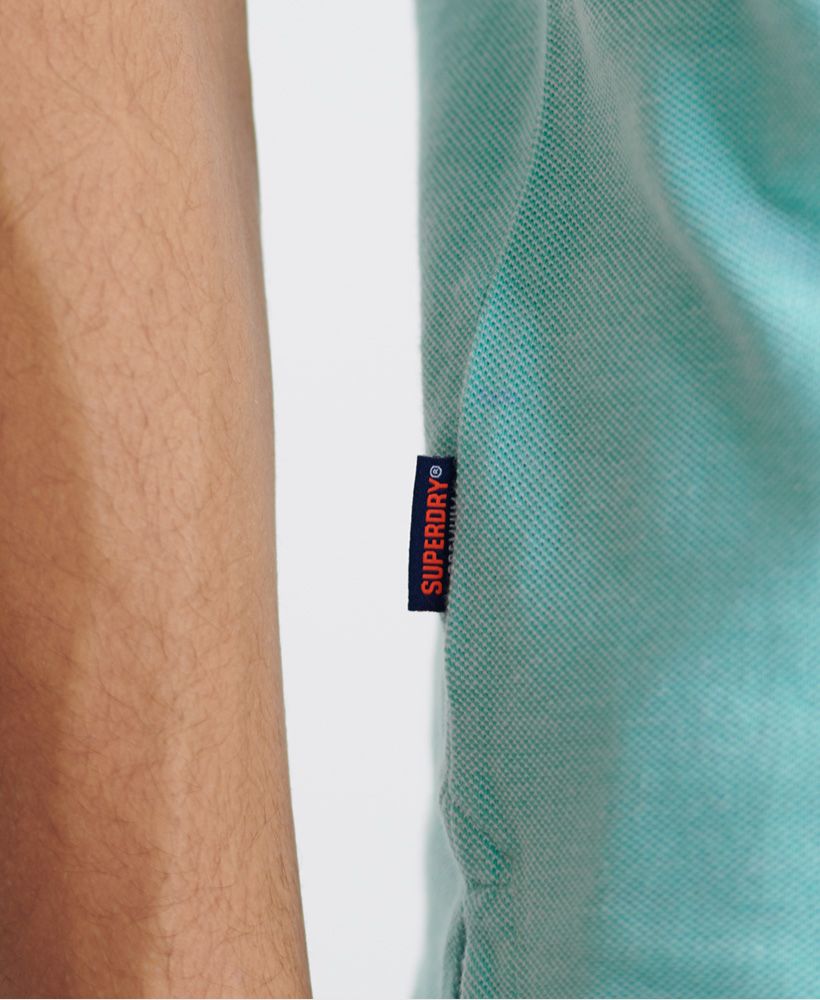 Superdry men's Classic pique short sleeve polo shirt. This classic style polo shirt features a half button fastening, short sleeves and reinforced side splits. Completed with a Superdry logo tab on the side seam and an embroidered Superdry logo on the chest.Made with Organic Cotton - Grown using only organic inputs and no artificial chemicals, which leads to improved soil condition, stronger biodiversity and better health among the cotton growers and uses between 60-90% less water to grow. By 2030, all Superdry Cotton will be Organic.Slim fitMade with Organic Cotton - Made using cotton grown using organic farming methods which minimise water usage and eliminate pesticides, maximising soil health and farmer livelihoods.