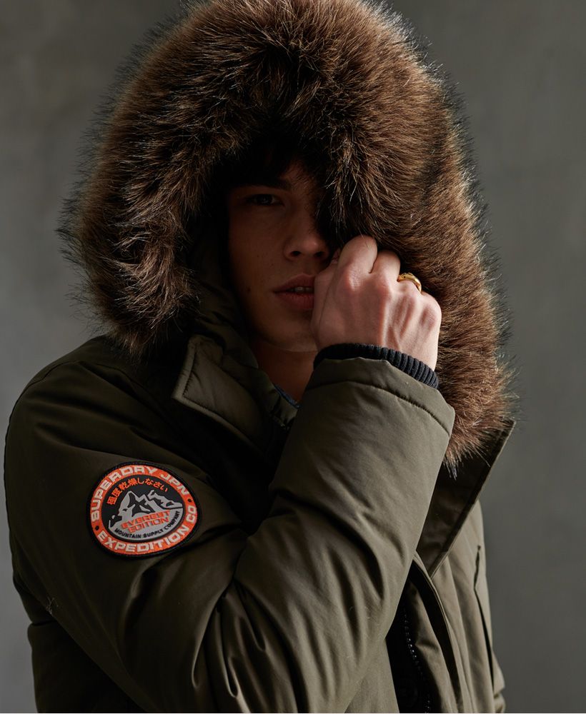 Superdry men's Everest Parka jacket. Your trusty goes-with-everything, beats-the-cold jacket features a four pocket popper design with fleece lining and ribbed cuffs for your comfort. Also featured is a zip and button fastening with a removable faux fur trim on the hood. Both the hood and waistline feature a drawstring to adjust to suit. Complete with an inner pouch pocket and Superdry logo badge on one shoulder, this jacket is this season's must-have.