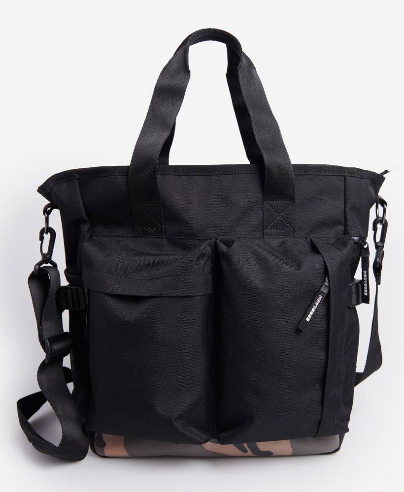 Superdry men's Commuter tote bag. A spacious bag featuring a large main compartment with multiple pockets and a sleeve inside, an open mesh pocket on the back, two large pockets on the front, an open mesh pocket on one side and a zip fastened pocket on the other side, two grab handles, an anti-scuff panel on the bottom, and a removable and adjustable shoulder strap with padding. Finished with a Superdry logo patch on one side.H 39cm x W 35cm x D 17cm