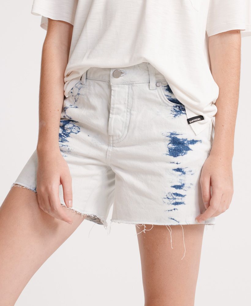 Superdry women's Denim Mid Length shorts, These shorts feature a classic five pocket design, a button and zip fastening, belt loops and a raw hem. These shorts are complete with a Superdry logo patch on the back of the waistband.