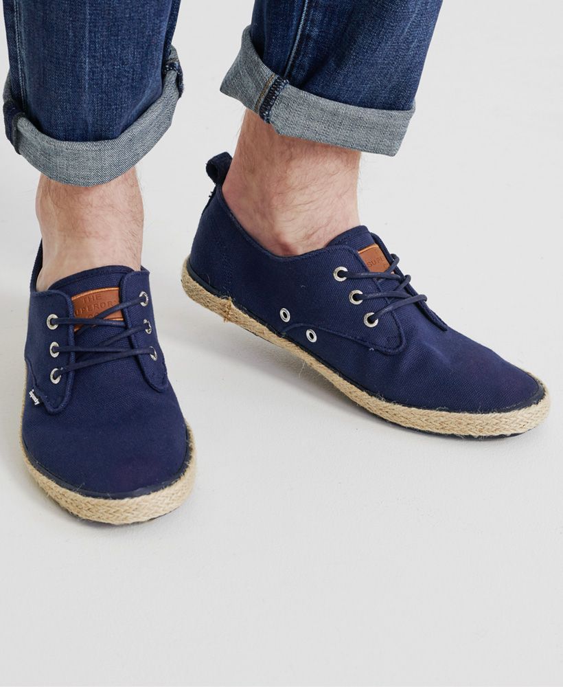 Superdry men's Skipper shoes. These shoes have a woven finish around the sole and feature a three eyelet pair fastening. The Skipper shoes have a Superdry patch on the tongue with debossed branding and are finished with a Superdry logo tab on the side.