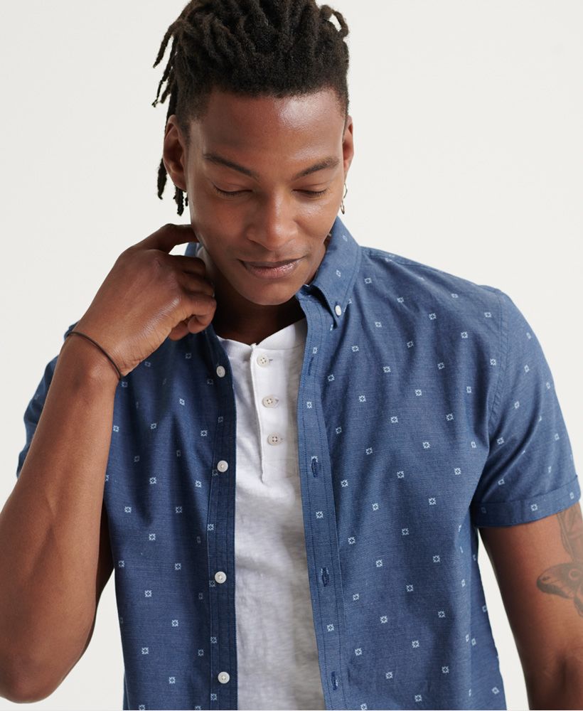 Superdry men's Classic Shoreditch Print short sleeved shirt. An eye-catching addition to your smart-casual wardrobe, this shirt features an all over print design, short sleeves and a button down fastening. Finished with a Superdry logo patch on the placket.