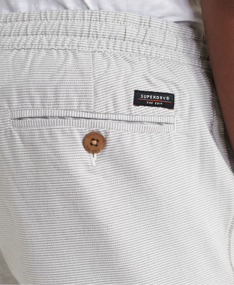 Superdry men's Edit taper drawstring shorts. These shorts feature a drawstring elasticated waistband, two front pockets and one back pocket with a button fastening. Finished with a Superdry logo patch above the back pocket.