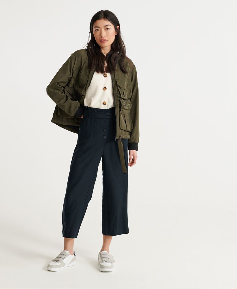 Superdry women's Edit linen trousers. A classic lightweight linen blend, these trousers feature a wide leg design, button fastening, two front pockets and a tie belt with loops for a flattering waistline. Finished with a ruched waistband and metal Superdry logo badge on one front pocket.