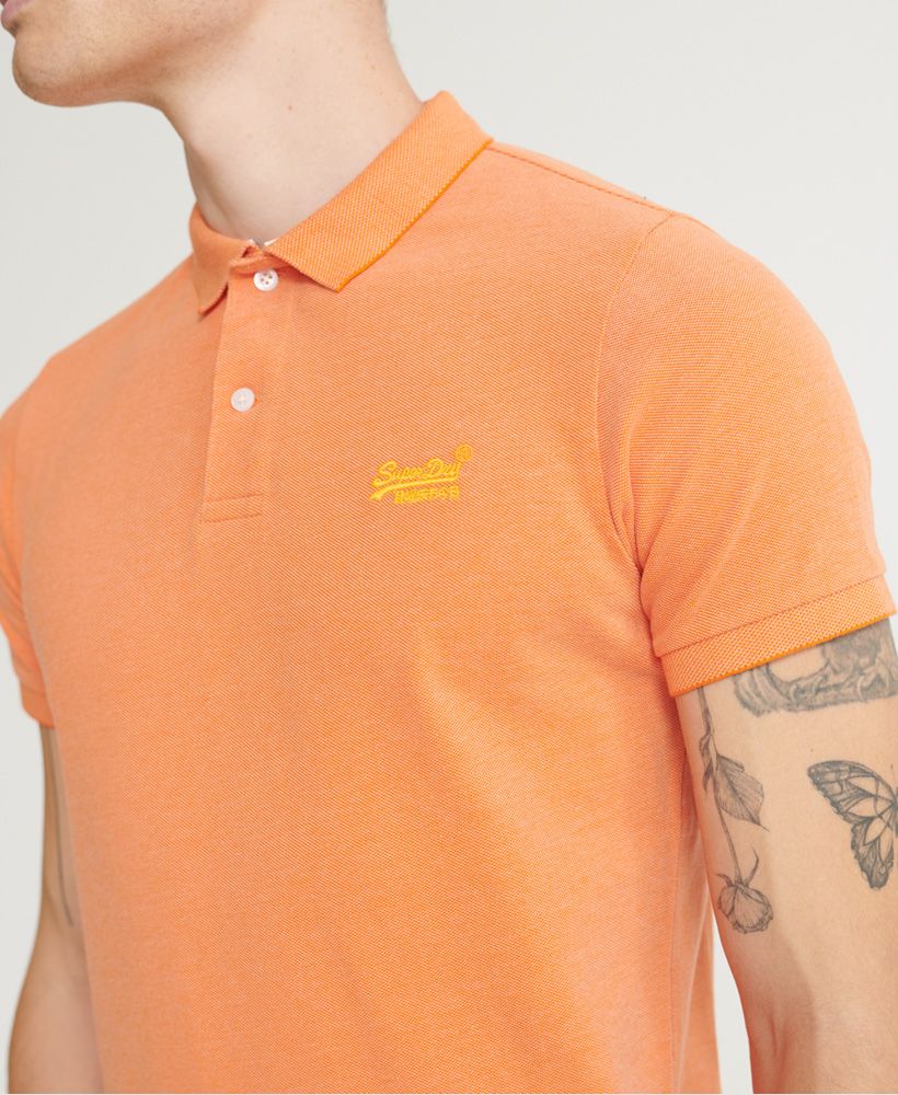 Superdry men's Classic pique short sleeve polo shirt. This classic style polo shirt features a half button fastening, short sleeves and reinforced side splits. Completed with a Superdry logo tab on the side seam and an embroidered Superdry logo on the chest.Made with Organic Cotton - Grown using only organic inputs and no artificial chemicals, which leads to improved soil condition, stronger biodiversity and better health among the cotton growers and uses between 60-90% less water to grow. By 2030, all Superdry Cotton will be Organic.Slim fitMade with Organic Cotton - Made using cotton grown using organic farming methods which minimise water usage and eliminate pesticides, maximising soil health and farmer livelihoods.