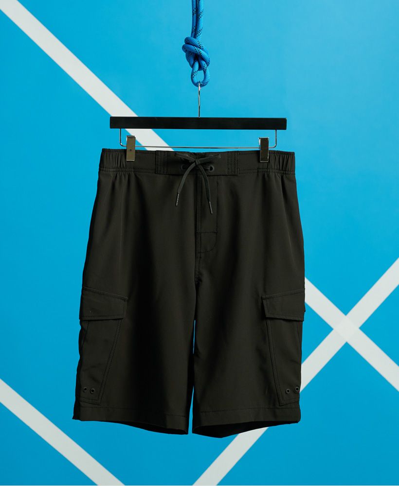 Superdry men's Worldwide Cargo boardshorts. These shorts feature a drawstring detailing with an elasticated waistband, two side hook and loop pockets, a back zip pocket with a loop for your locker key and a loop on the back essential for drying. Complete with a Superdry logo badge on one pocket.