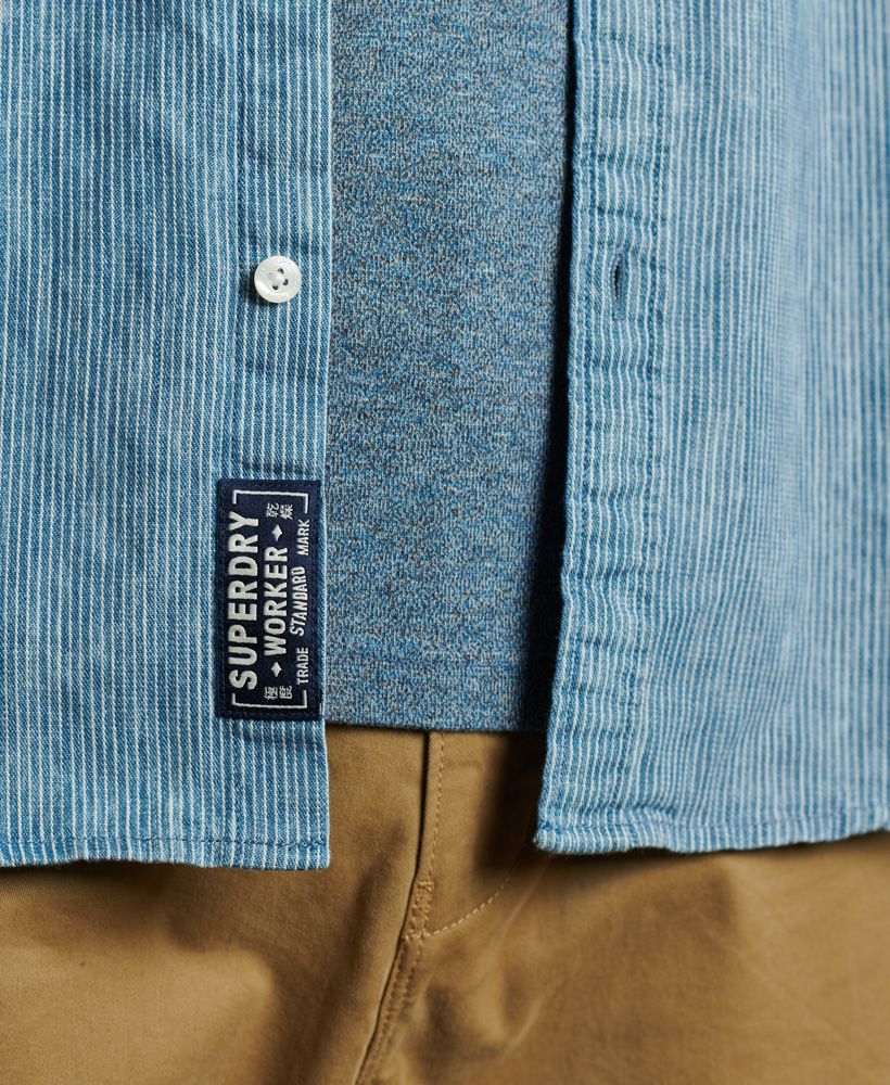 Superdry men's Loom worker shirt. This short sleeved shirt features a patterned design, a button down fastening, a straight collar and two chest pockets. The shirt is finished with a Superdry logo patch on one pocket, and a Superdry logo patch on the bottom of the placket. Pair with jeans or chinos for a smart casual look.
