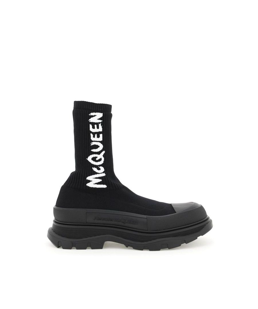 Alexander McQueen ankle boots with ribbed knit sock pattern upper with contrasting logo. Oversized rubber lugged sole. Textured rubber overlay and tone-on-tone logo. Unlined interior.
