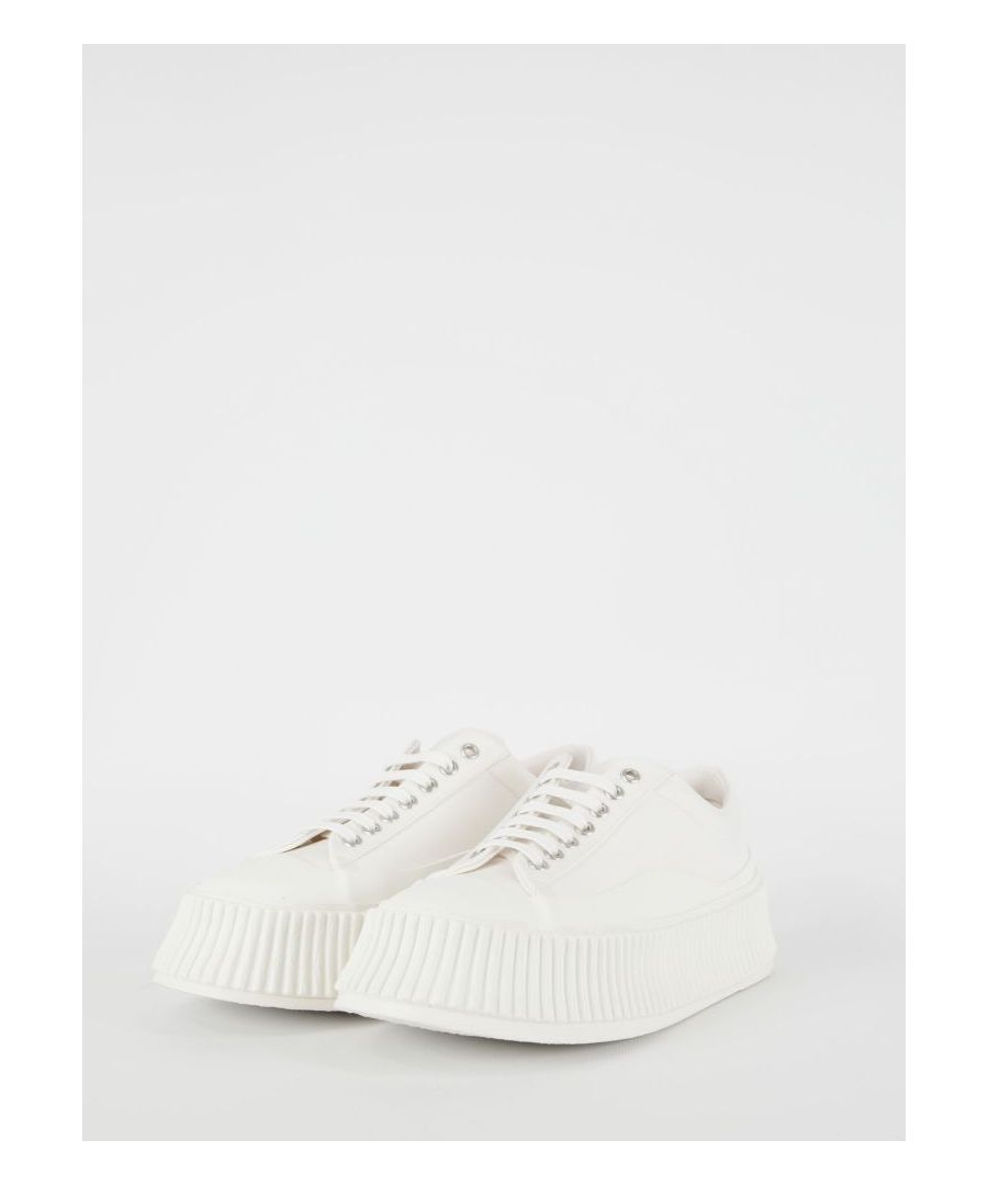 Platform sneakers in cream-colored semi-lined canvas with vulcanized rubber sole. They feature lace-up closure and Jil Sander logo branded insole.