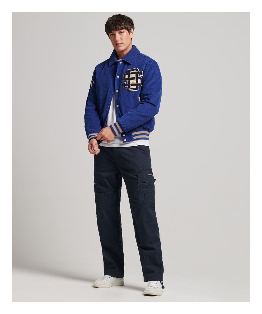 Gebaseerd op een iconisch stukje Americana, is dit jack een andere versie dan het klassieke Varsity-jack. Het fijne corduroy materiaal van deze jas zorgt niet alleen voor extra textuur en een zacht gevoel maar geeft dit Varsity cordury bomberjack ook een onverwachte look. De onmisbare vintage look en feel van dit klassieke model blijven behouden.Casual pasvorm – de klassieke Superdry-pasvorm. Niet te nauwsluitend, niet te ruim, precies goed. Kies je gebruikelijke maatKlassieke varsity-stijlBomberjack-pasvormCorduroyDrukknoopsluitingTwee buitenzakken met drukknopen en contrasterende biesGeribde mouwboorden en zoom met contrasterende biezenVolledig gewatteerde voeringEén binnenzakOp varsity geïnspireerde patches