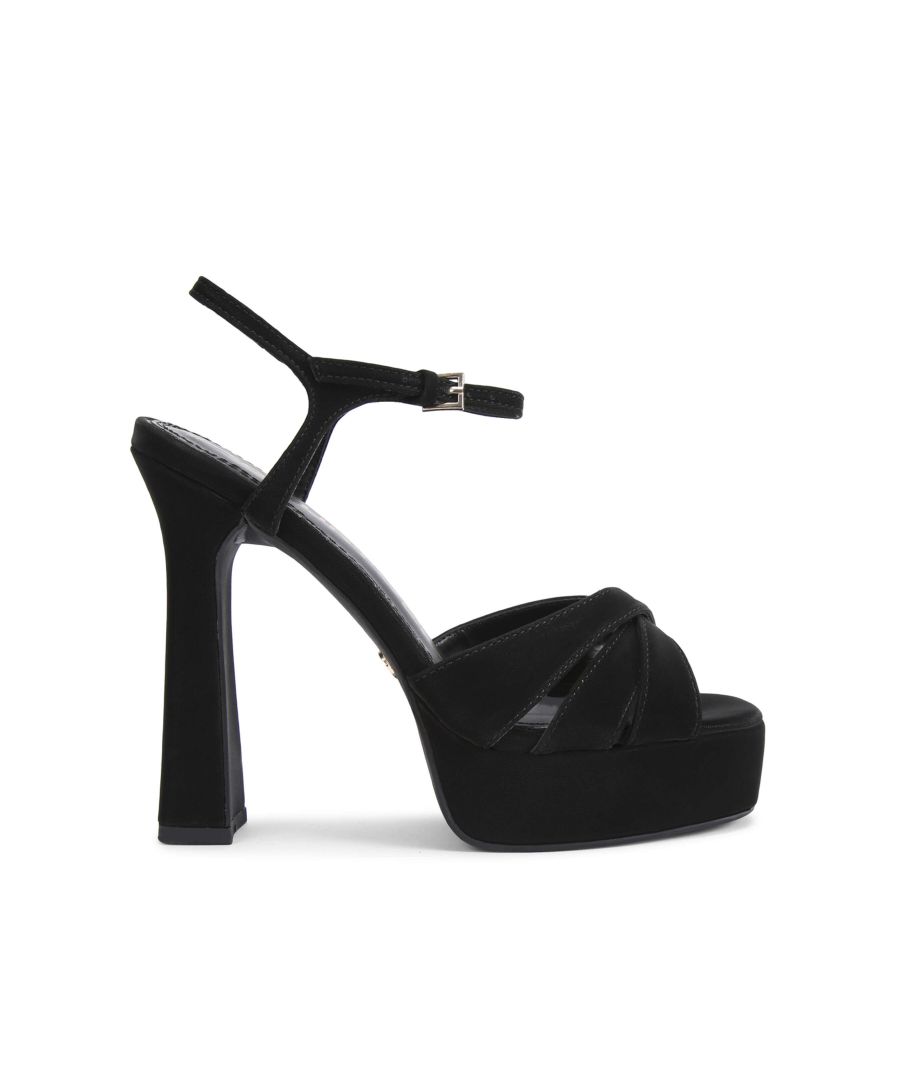 The Simran platform heel features a black microsuede upper with strappy toe. The ankle is fastened with small gold buckle. Heel height: 13.5cm. Platform height: 3cm. Pitch height: 10.5cm. Gold tone KG stud on the outer sole. This product is registered with The Vegan Society.